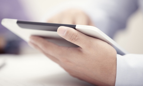 Hands of businessman using tablet PC at office